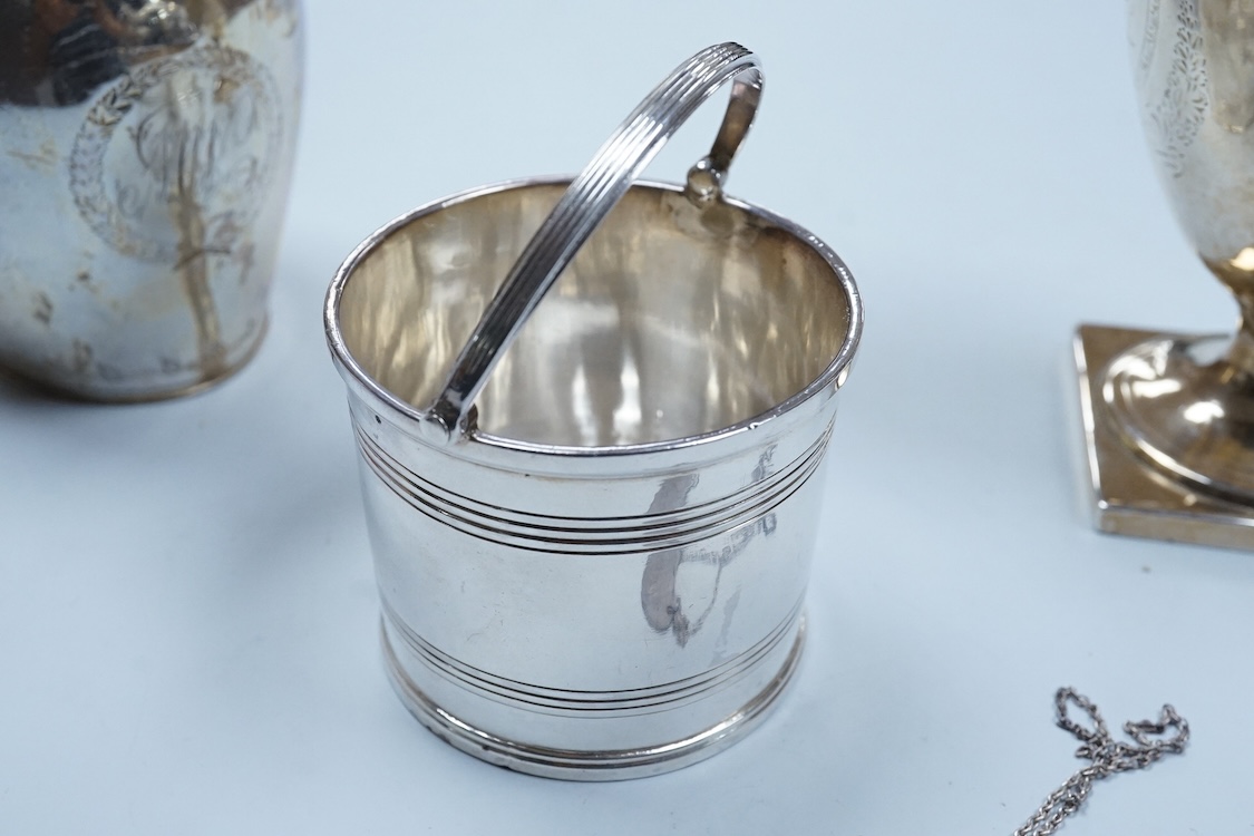 A George III silver cream jug, of oval form, London, 1801, 11cm, a George III silver helmet shaped cream jug, London, 1793, a George III small silver sugar pail, London, 1799 and a George V silver 'whisky' label, 8.4oz.